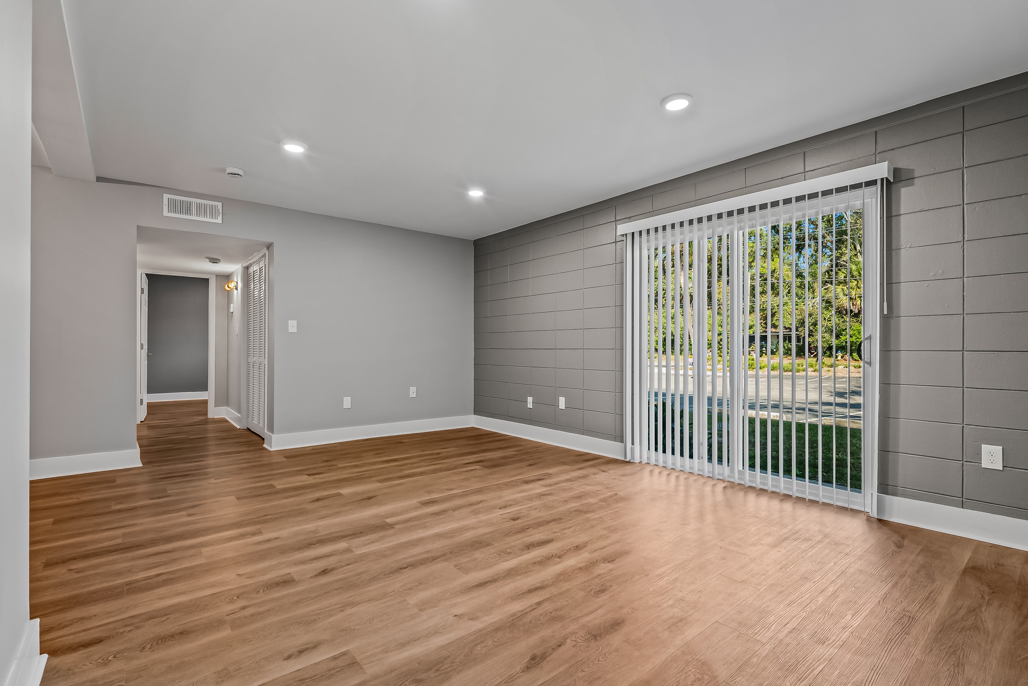A room with wooden floors and a sliding glass door. at Serenity Place Central, Florida, 32304